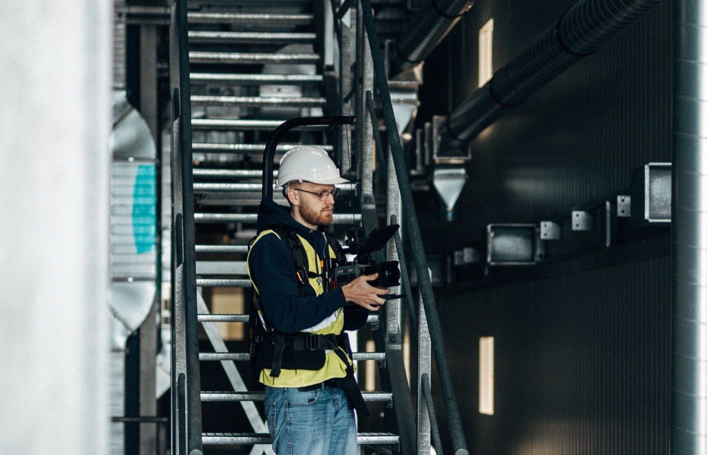 Daniel mit Kamera-Rig auf einer Industrietreppe